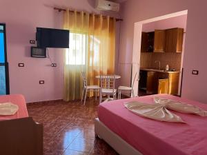 a bedroom with a bed and a kitchen with a table at Aragosta Shengjin 2 in Shëngjin