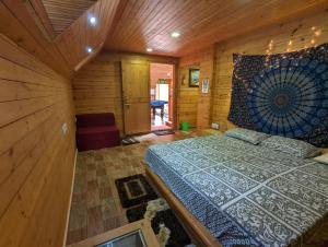 een slaapkamer met een bed in een houten hut bij The Door to Nirvana Backpackers Hostel Kotagiri in Kotagiri