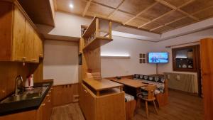 una cucina con un tavolo e una sala da pranzo di Casa Cortina - presso Sussy Residence a Falcade
