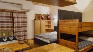 una camera da letto con un letto a castello e un tavolo di Casa Cortina - presso Sussy Residence a Falcade