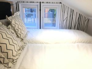 - un lit avec des draps et des oreillers blancs devant 2 fenêtres dans l'établissement P57 - Riverside Family Pod with Hot Tub, à Bethesda 3 autres photos