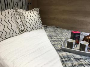 - un lit avec un plateau avec deux tasses et un plateau avec deux tasses dans l'établissement P57 - Riverside Family Pod with Hot Tub, à Bethesda