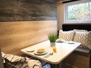 une table blanche avec deux assiettes de nourriture dans l'établissement P57 - Riverside Family Pod with Hot Tub, à Bethesda