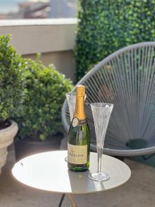 eine Flasche Champagner und ein Glas Wein auf dem Tisch in der Unterkunft Olympic Boutique in Constanţa