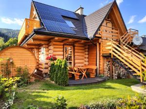 a log cabin with solar panels on the roof at Sykowno chata in Szczyrk