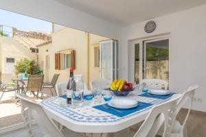 a white dining room with a table and chairs at Vila Ca Shermano in Colonia de Sant Pere