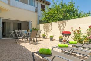 a patio with tables and chairs and a grill at Vila Ca Shermano in Colonia de Sant Pere