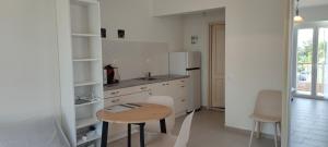 a small kitchen with a table and a refrigerator at Meraki Skopelos in Skopelos Town +21 photos