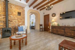 a living room with a fireplace and a table at Vila Ca Shermano in Colonia de Sant Pere