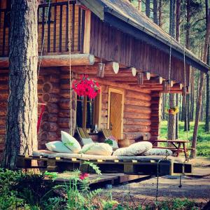 una cabaña de madera con almohadas delante en Piparmētras, en Mērsrags