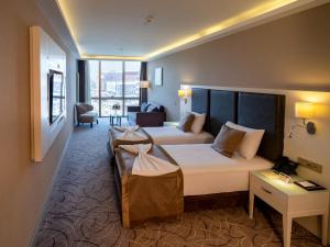 A bed or beds in a room at The Conforium Hotel Van