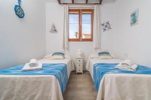 two twin beds in a room with a window at Vila Ca Shermano in Colonia de Sant Pere