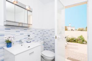 a bathroom with a toilet and a sink at Vila Ca Shermano in Colonia de Sant Pere +32 photos