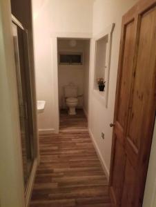 a hallway of a bathroom with a toilet and a door at Just Renovated Galway City Apartment in Galway