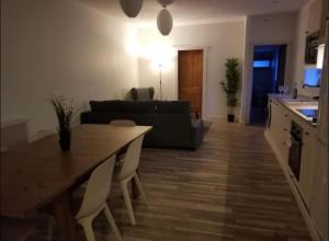 a kitchen and a living room with a table and chairs at Just Renovated Galway City Apartment in Galway