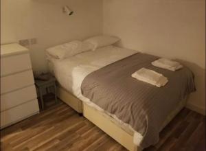 a bedroom with a bed with two towels on it at Just Renovated Galway City Apartment in Galway