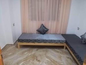 ein Bett mit zwei Kissen auf einem Zimmer in der Unterkunft S 2 1km from the beach in Kelibia in Kelibia