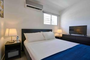 een slaapkamer met een groot bed en een flatscreen-tv bij Escape Studio Apartment Close to Agora Mall in Santo Domingo
