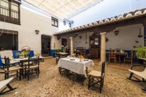 un patio avec des tables et des chaises dans un bâtiment dans l'établissement Hotel Rural Tia Pilar, à Almagro