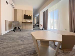 a living room with a table and a tv at Olympic Boutique in Constanţa