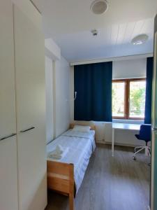 a bedroom with a bed and a blue curtain at Harju Apartments in Jyväskylä