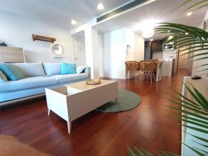 sala de estar con sofá azul y mesa en Expoholidays - Apartamento Rueda Lopez (7ºB), en Almería