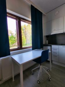 于韋斯屈萊的住宿－Harju Apartments，厨房配有白色的桌子和蓝色的窗帘