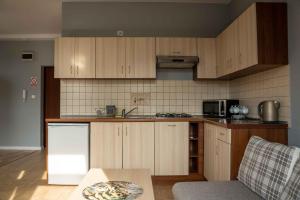 una cucina con armadi in legno e un tavolo in una stanza di Apartamenty Na Winklu Green a Unieście 1 altra foto