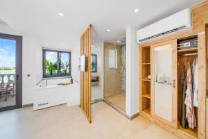 a bathroom with a shower and a walk in closet at Drossia Residenza Boutique Hotel Malia in Malia