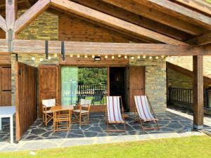 een patio met stoelen, een tafel en een houten plafond bij Casa con impresionantes vistas en Martinet in Martinet