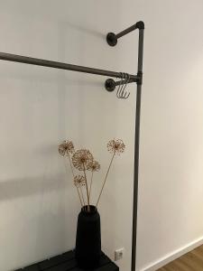 a black vase with flowers in a room at Apartmenthaus Stade Schwingewiesen Apartment 1 in Stade