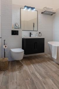 un bagno con un lavandino, una vasca e uno specchio di Olympic Boutique a Constanţa
