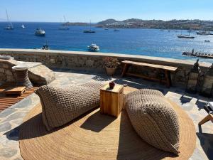 a patio with a bench and a view of the water at Beachfront Mykonos Guest House in Ornos