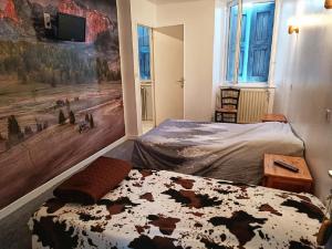 1 dormitorio con 1 cama y una pintura en la pared en Hôtel Restaurant L Orée du Vercors, en Montmaur-en-Diois