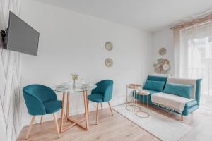 een woonkamer met een bank en een tafel en stoelen bij L'élégant portes de Paris- Parking-5'RER B in Gentilly