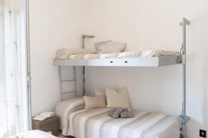 two bunk beds in a white room with a bed at [V.LE DELLA REPUBBLICA] Bilocale vicino al mare. in Pietra Ligure