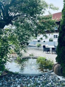 einen Teich im Garten mit Tisch und Stühlen in der Unterkunft Landhotel Zerlaut in Kißlegg