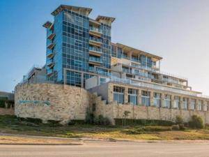a tall building sitting on top of a stone wall at Nautica in Mossel Bay