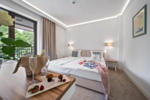 een slaapkamer met een bed, een tafel en een raam bij HVD Nympha Hotel - Adults Only - Private Beach & Free Parking in Goudstrand