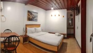 a small bedroom with a bed and a table at Marion Hotel in Manila