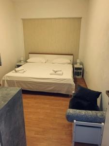 a bedroom with a white bed and a chair at Diklo beach apartments 1 in Zadar