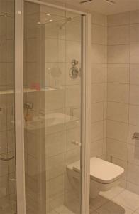 a bathroom with a toilet and a glass shower at Haus Meeresblick - Ferienwohnung Wellenreiter A 1.13 (Ref. 134029) in Baabe