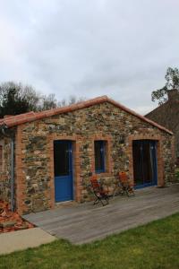 a stone building with two chairs on a wooden deck at Maison de 3 chambres avec jardin clos et wifi a Mouzillon in Mouzillon