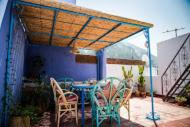 a patio with a table and chairs under a roof at Casa La Palma in Chefchaouen