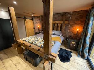 Schlafzimmer mit Himmelbett und Ziegelwand in der Unterkunft The Mash Tun - monstrous swank in a sleepy village in Whaplode