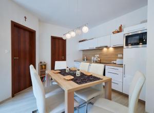 eine Küche und ein Esszimmer mit einem Holztisch und Stühlen in der Unterkunft Apartment Bonita Tále in Bystrá