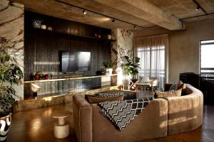 ein Wohnzimmer mit einem Sofa und einem TV in der Unterkunft Hallmark Hotel by BON Hotels in Johannesburg