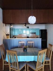 - une cuisine avec une table bleue, des chaises et un réfrigérateur dans l'établissement Apartman Ivan 2, à Brela