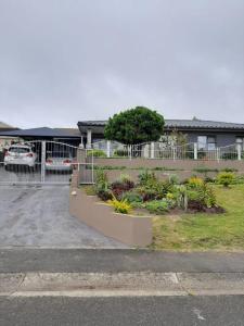 een parkeerplaats met een bos planten en een gebouw bij Ariah's Guesthouse and Self Catering in East London