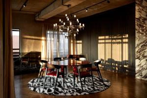 a dining room with a table and chairs and a chandelier at Hallmark Hotel by BON Hotels in Johannesburg